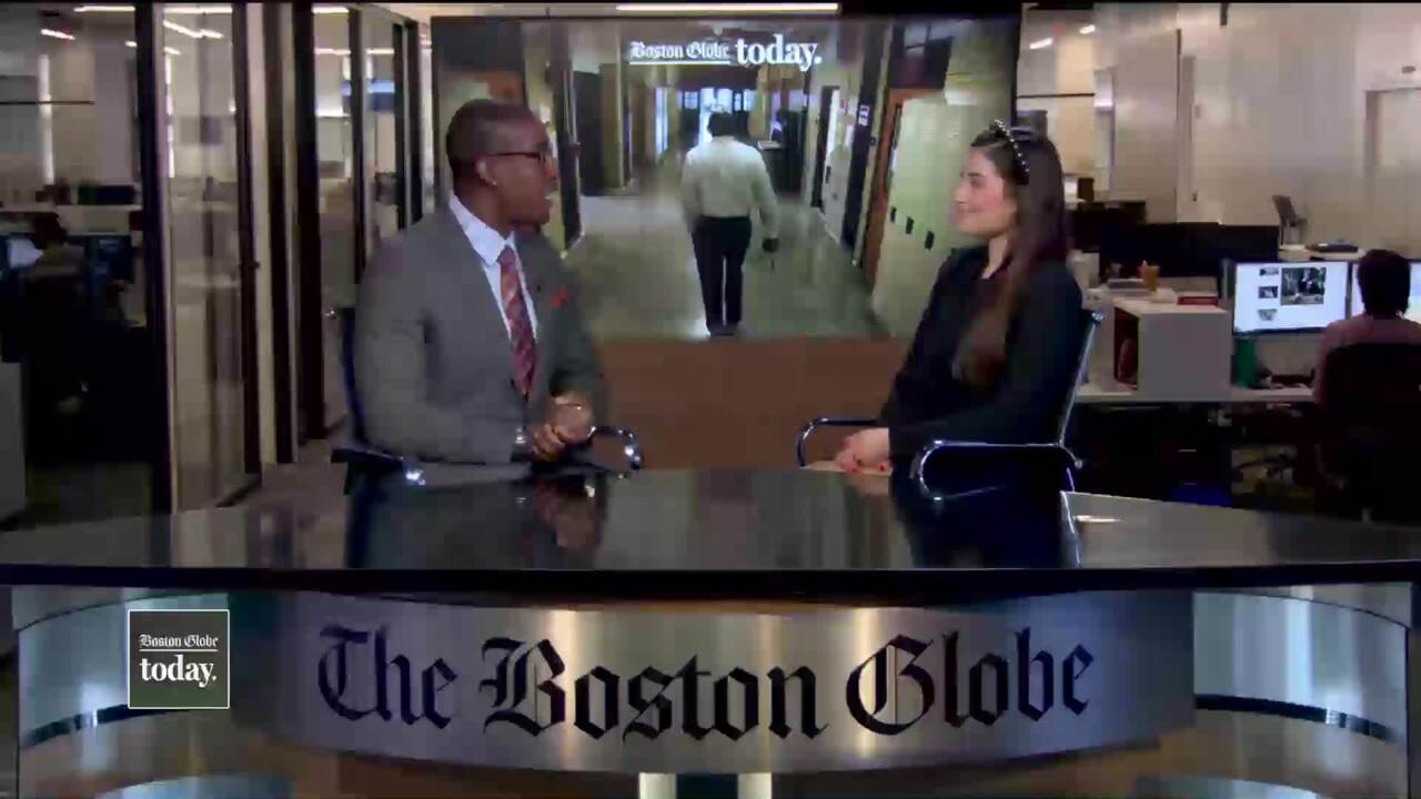 African American man and White woman sitting and talking at news station