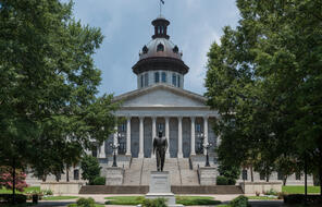 Southeast view of the South Carolina State House with Strom Thurmond statue in the foreground.