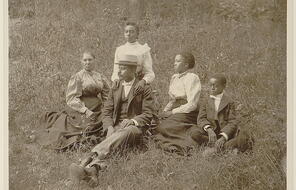 A portrait of an African American family seated on a lawn.