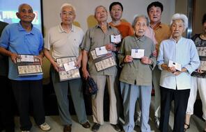 Survivors of the 1937 Nanjing Massacre pose for a photo during a ceremony in Nanjing on July 6, 2013.