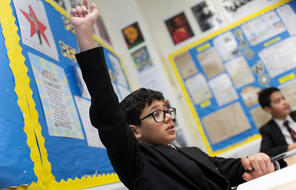 A student raises his hand in class.