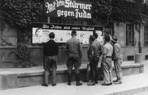 An issue of the antisemitic propaganda newspaper Der Stürmer (The Attacker) is posted on the sidewalk in Worms, Germany, in 1935. The headline above the case says, ""The Jews Are Our Misfortune.""