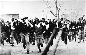 Group of black South African schoolboys running frantically