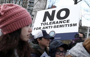 Protestor holding "No Tolerance for Anti-Semitism" sign at demonstration