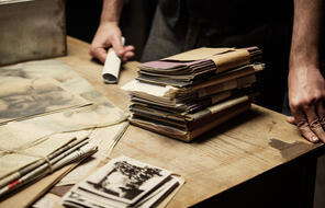 A still of the documentary film "Who Will Write Our History" depicting a stack of papers.