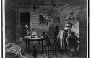 Engraving showing African American family in a humble home. Woman is cooking at the fireplace, man seated alongside, and three children. A masked man from Ku Klux Klan is aiming a rifle in doorway; two more masked figures also peek in.