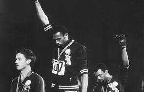 American track and field athletes Tommie Smith (C) and John Carlos (R), first and third place winners in the 200 meter race, protest with the Black Power salute as they stand on the winner's podium at the Summer Olympic games, Mexico City, Mexico, October 19, 1968. Australian silver medalist Peter Norman stands by.