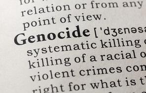 Close-up on dictionary definition of the word genocide including key descriptive words.