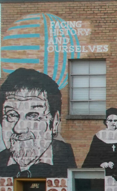 A black and white painting of Jose Guerrero on the Memphis Upstanders Mural, a painting on a brick wall in Memphis, TN.