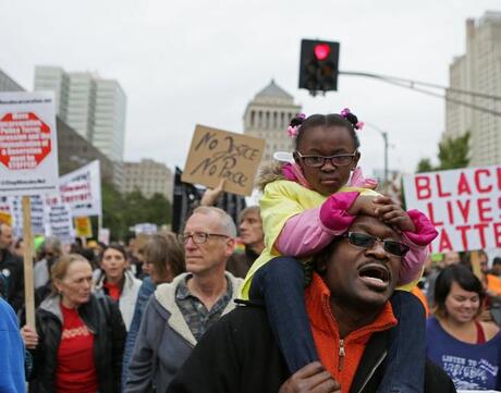 Darnell Taylor marches with his daughter, Lauren, 4, on his shoulders down Market Street to Kiener Plaza as part of a march against police violence downtown St. Louis, Mo., on Saturday, Oct. 11, 2014.  (AP Photo/St. Louis Post-Dispatch, Cristina Fletes-Boutte)
