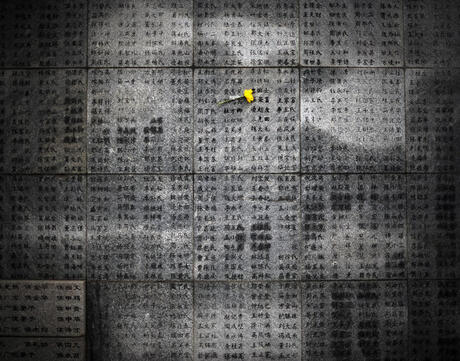 A flower is left on a wall engraved with victims names at the Memorial Hall of the Victims in the Nanjing Massacre.