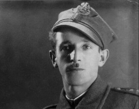 A young, white, mustachioed man wearing a uniform and a hat tilted to the side