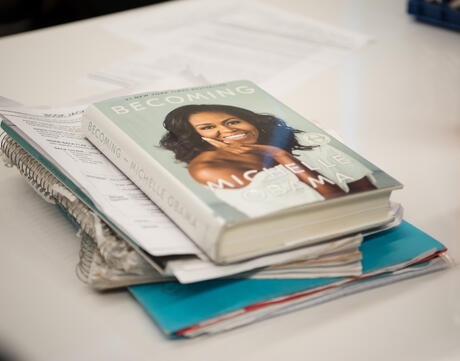 A stack of papers with Michelle Obama's "Becoming" on top.