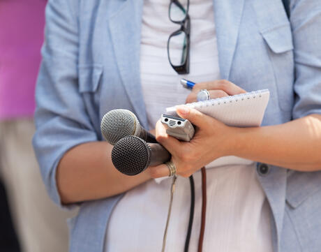 Reporter with microphones. 
