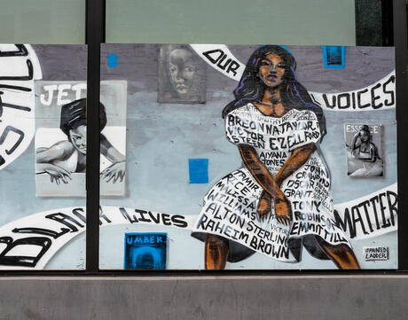Mural of two people with racial justice imagery and phrases