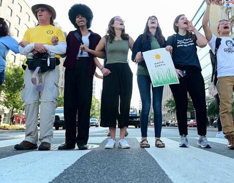 Demonstrators stand in a crosswalk to protest climate change.